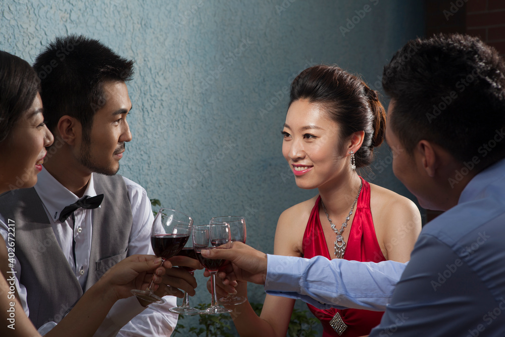 Four people sit together for dinner and chat 