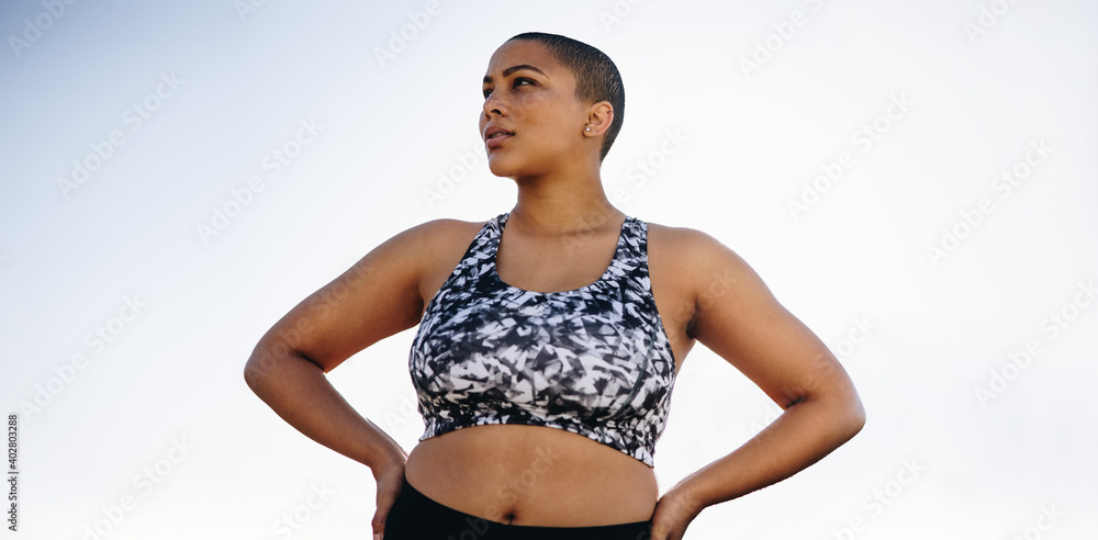 Curvy woman in sportswear with hands on hips