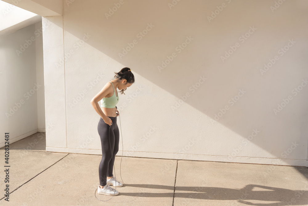 Beautiful asian woman outdoor exercise She jumps rope