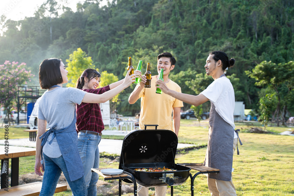 一群亚洲年轻男女在露营时碰瓷啤酒瓶