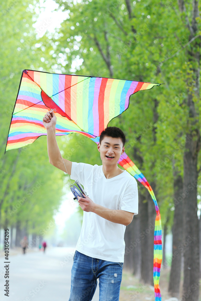 A young man flying a kite in the park