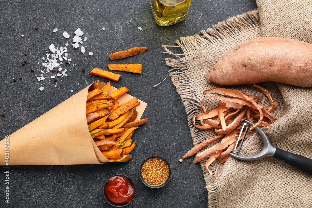 Paper bag with tasty cooked sweet potato on dark background