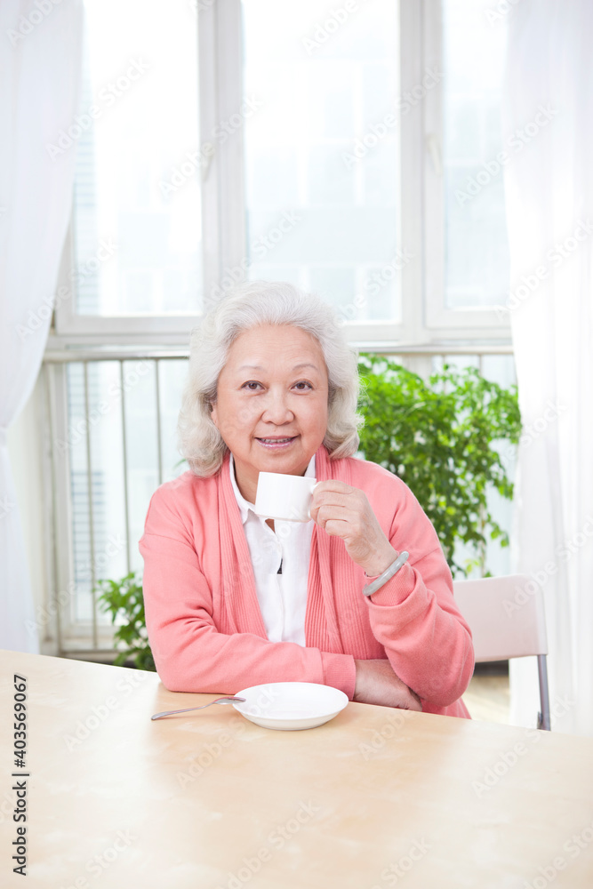 一位拿着茶杯的老年妇女