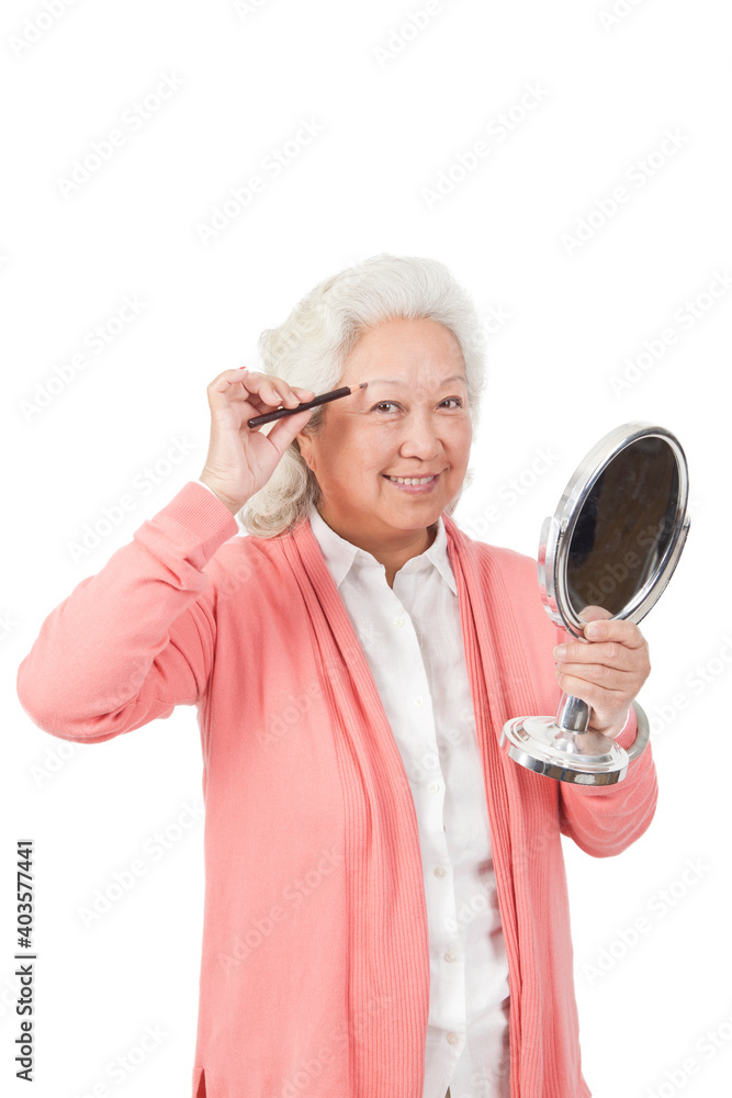 An happy old senior woman holding mirror 