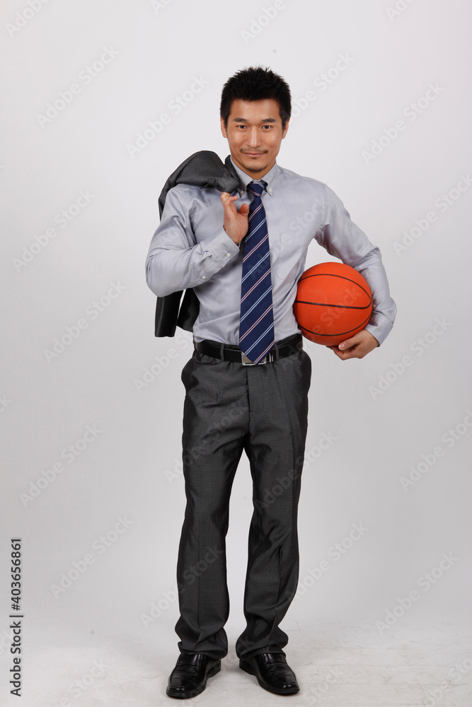 A business man exercising with playing basketball 