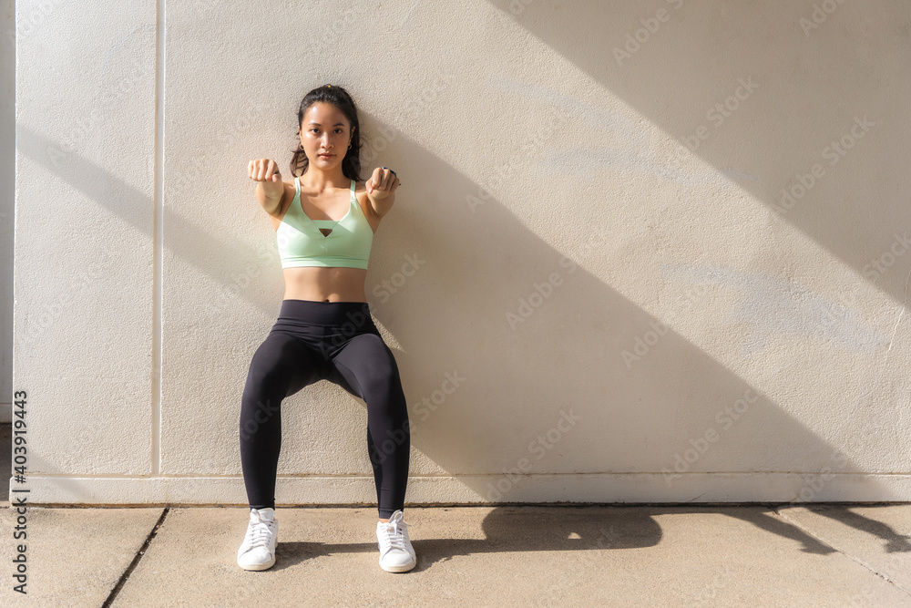 Beautiful Asian women doing wall sit