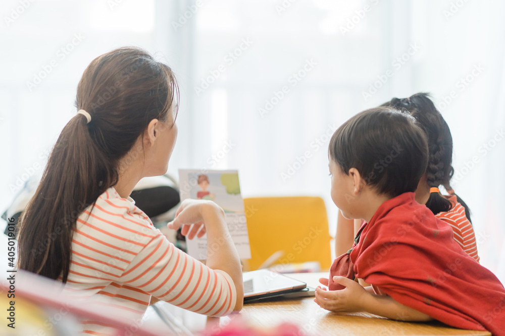 快乐的家庭封锁活动在家。亚洲母亲和孩子们正在学习圣经主日学校st