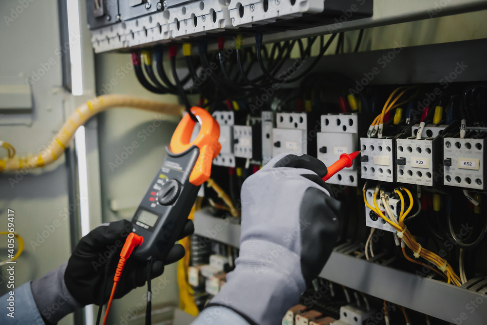 Electrical engineers test electrical installations and wiring on protective relays, measuring them w