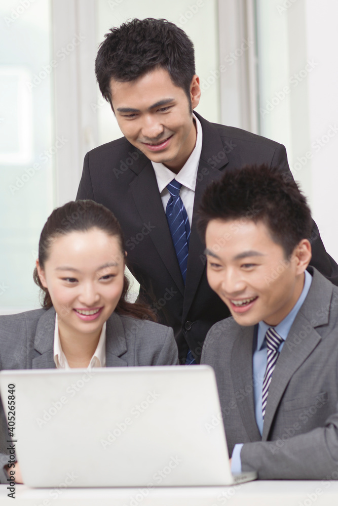 Group of businesspeople discussing working on computer