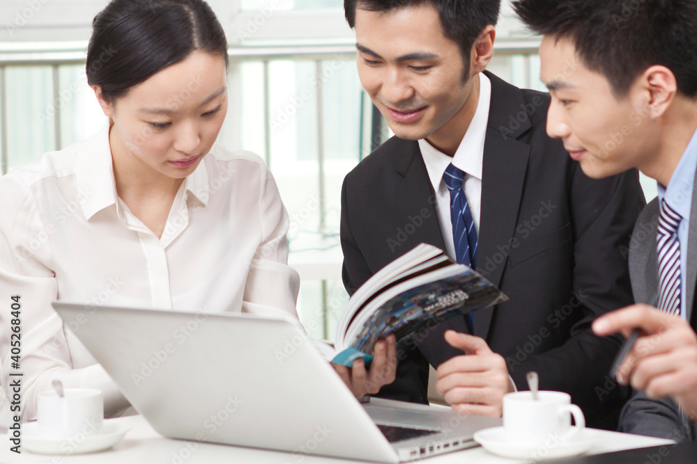 Group of businesspeople discussing with a magazine in office