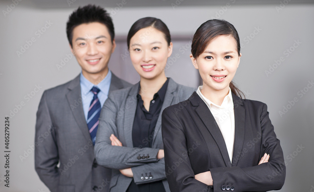 Four young office workers with hands crossed indoors,portrait