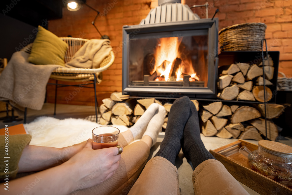 Couple lying by the burning fireplace in a cozy house in loft style