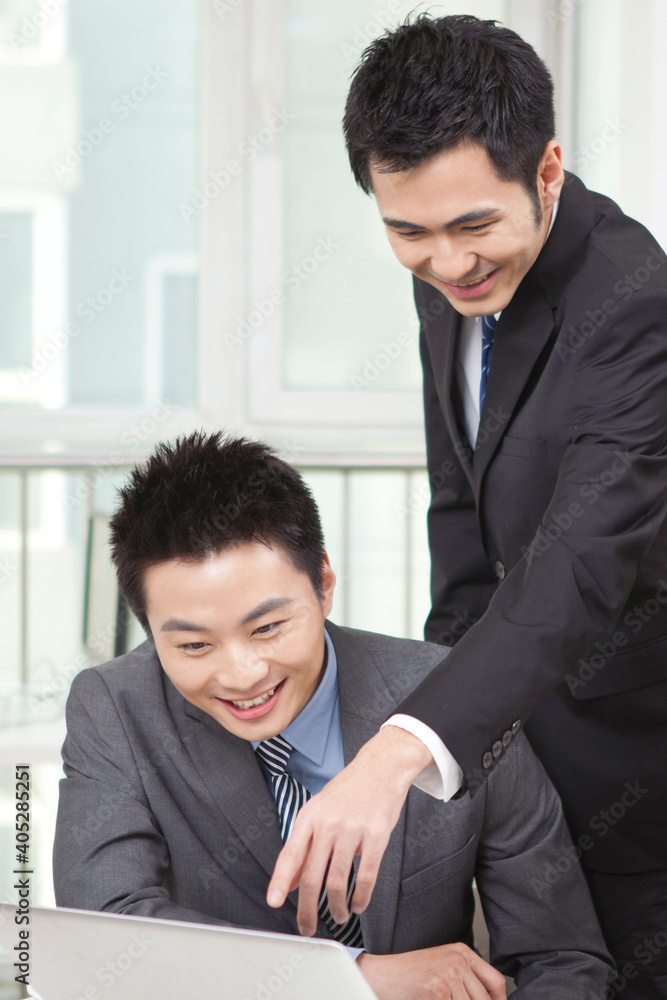 Group of businesspeople discussing working on computer