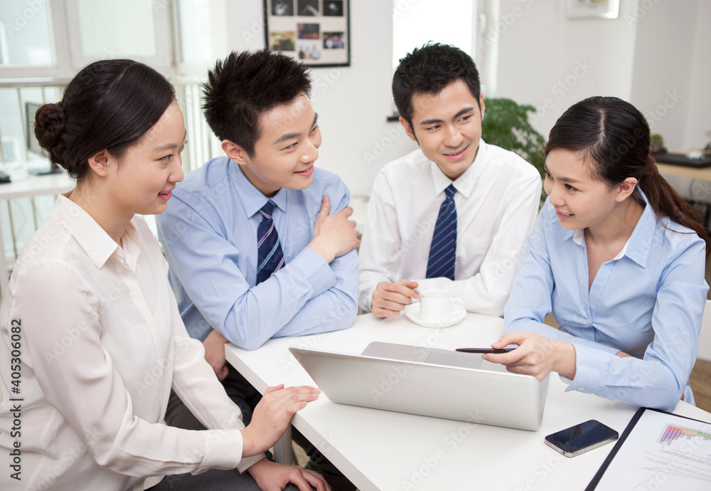 Group of businesspeople discussing working on computer