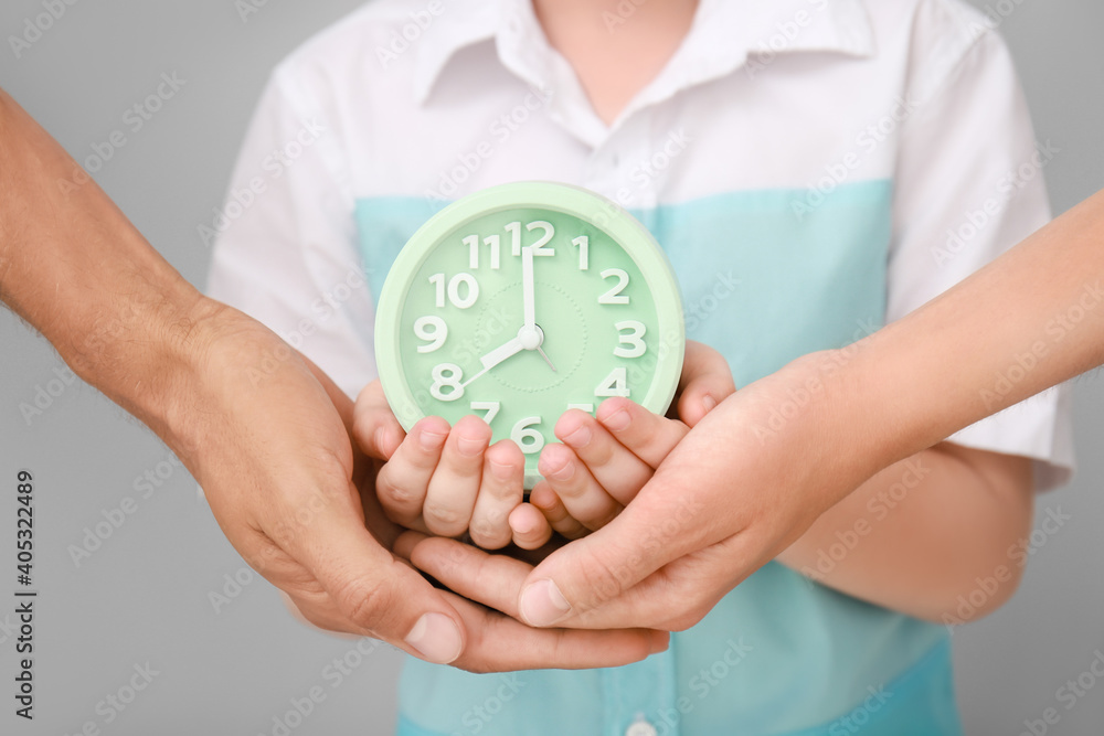 Hands of family with alarm clock, closeup