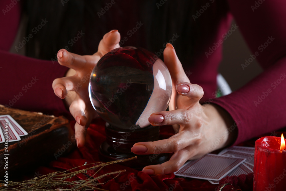 Fortune teller with crystal ball reading future at table