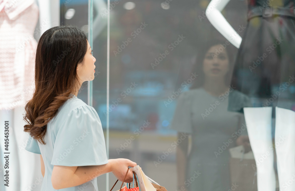 年轻女孩在商店外看衣服