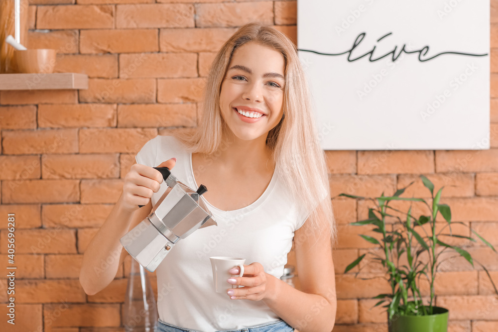 美丽的年轻女子在厨房喝热咖啡