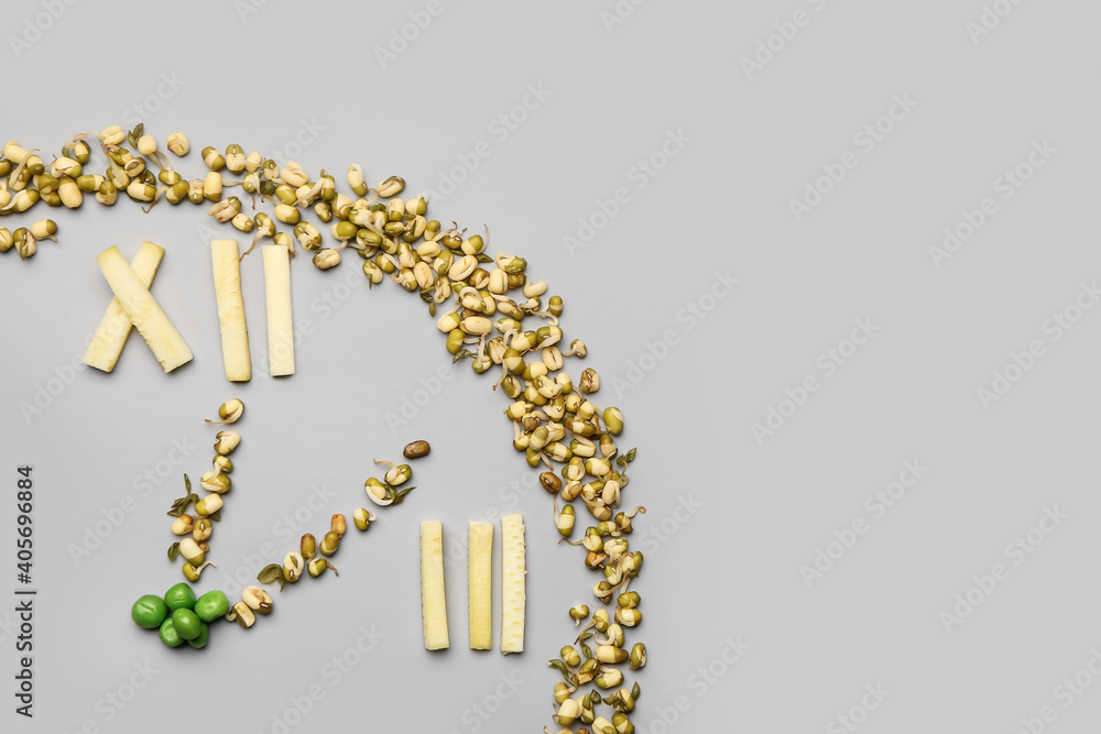 Clock made of food on grey background