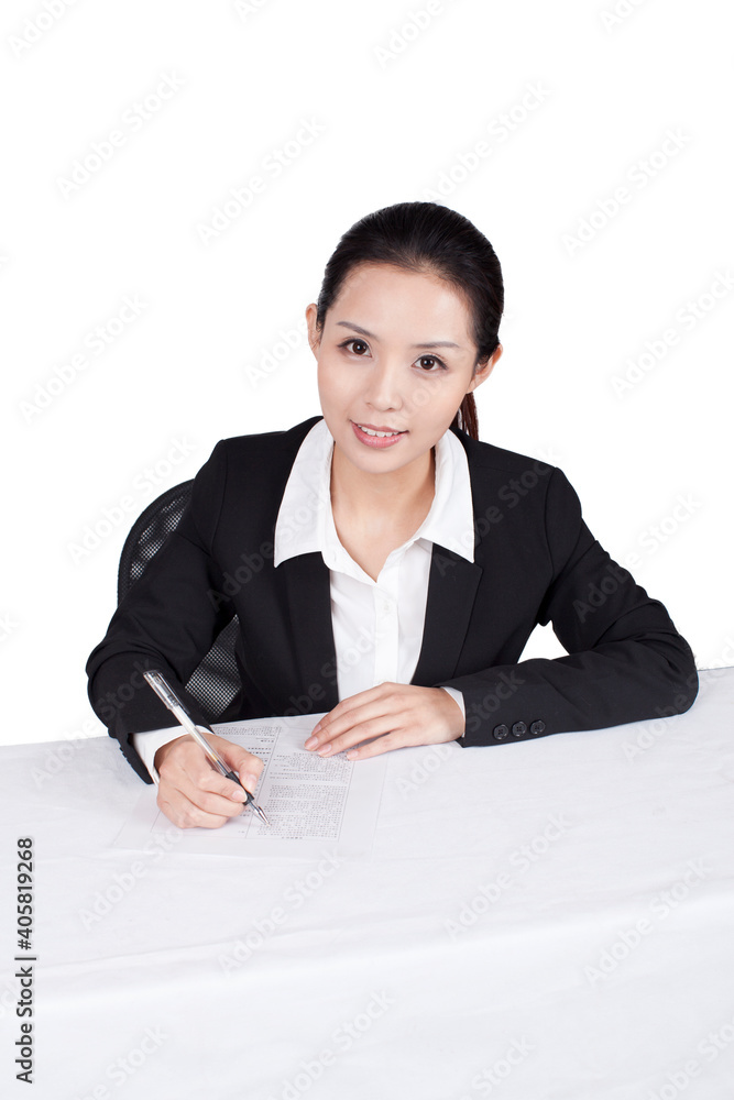 Businesswoman writting at a table with smile