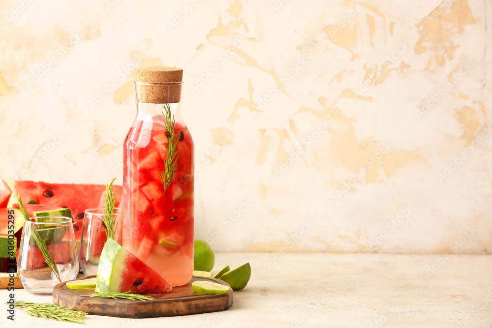 Bottle of fresh watermelon lemonade and glasses on table