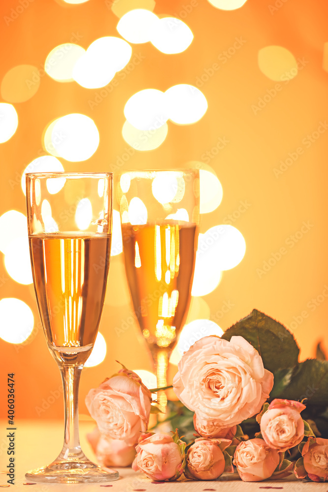 Glasses of champagne and beautiful flowers on table. Valentines Day celebration