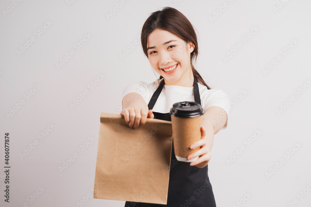 Portrait of a young waitress holding coffee cup and bag of cake