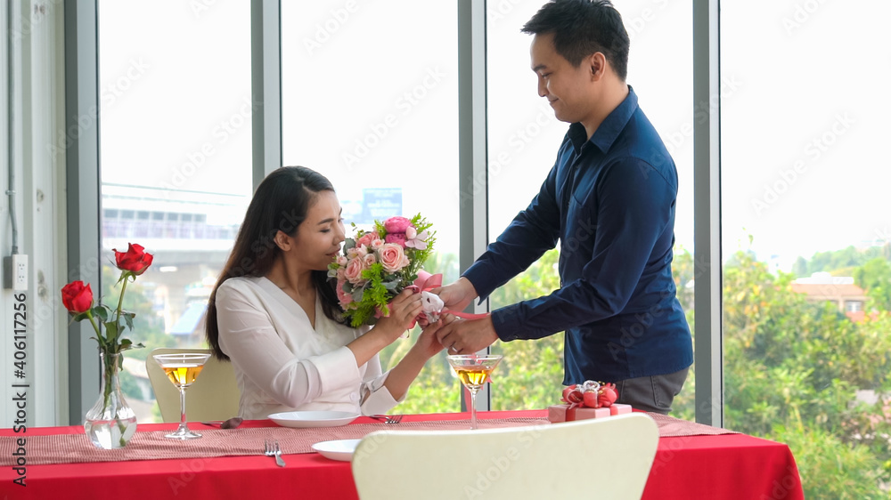 Romantic couple giving gift to lover at restaurant . Happy couple lifestyle .