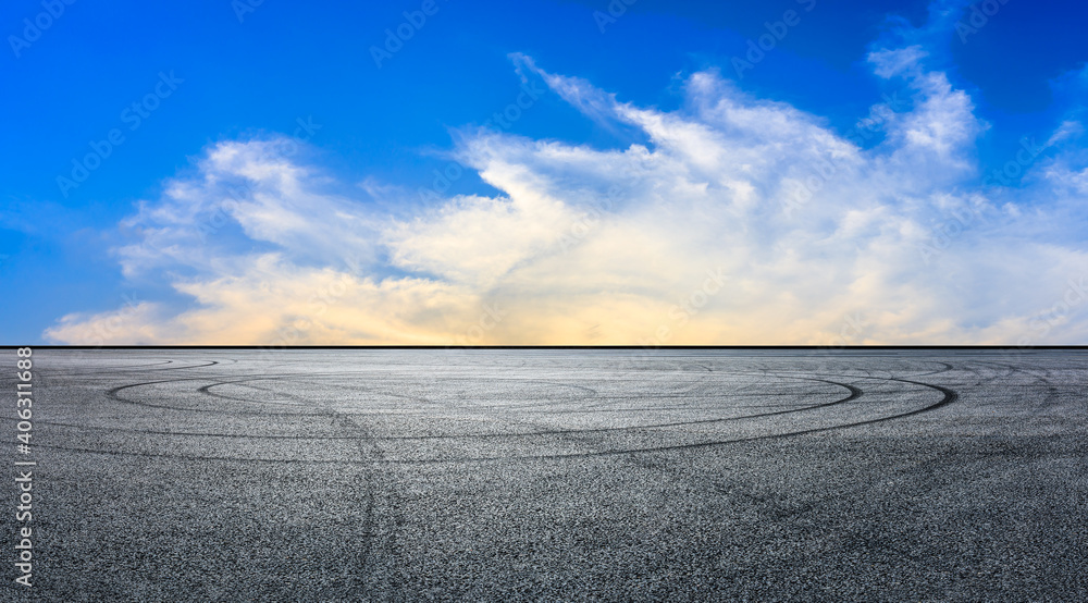 日落时的沥青赛道道路和天空云朵。道路地面背景。