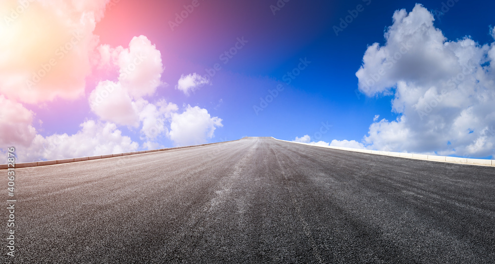 日落时的柏油路和天空云朵。道路背景。