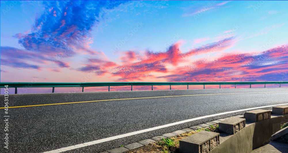 日落时的柏油路和天空云朵。道路背景。