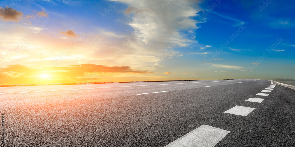 日落时的柏油路和天空云朵。道路背景。