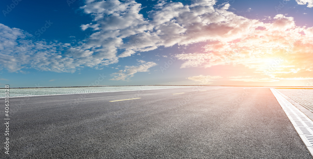 日落时的柏油路和天空云朵。道路背景。