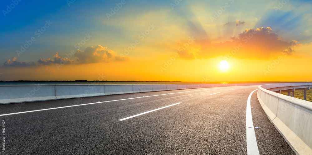 日落时的柏油路和天空云朵。道路背景。