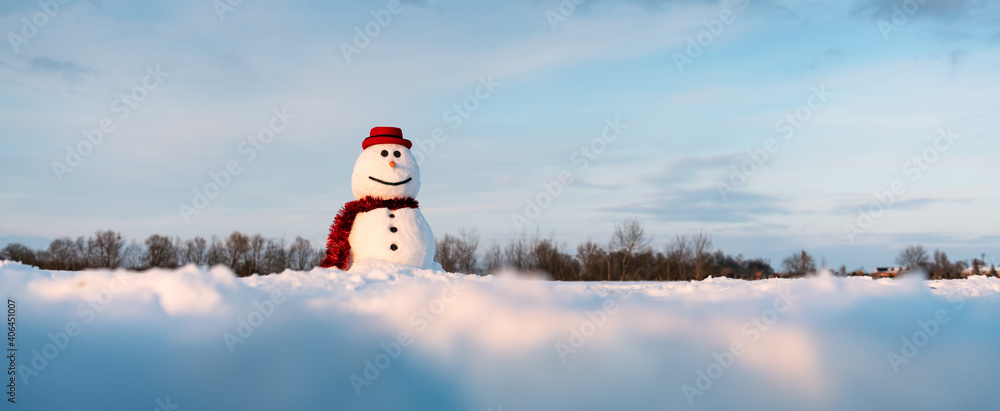 雪地上戴着时尚的红色帽子和红色鳞片的有趣雪人。全景照片是现场负责人的理想选择