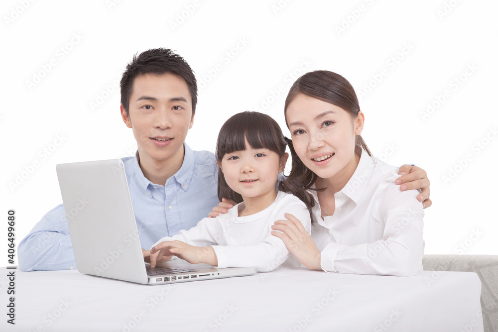 Portrait of daughter playing laptop with parents 