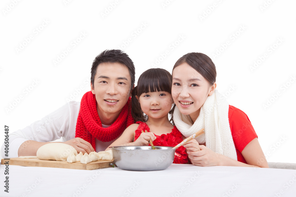 Portrait of daughter with parents making dumplings 