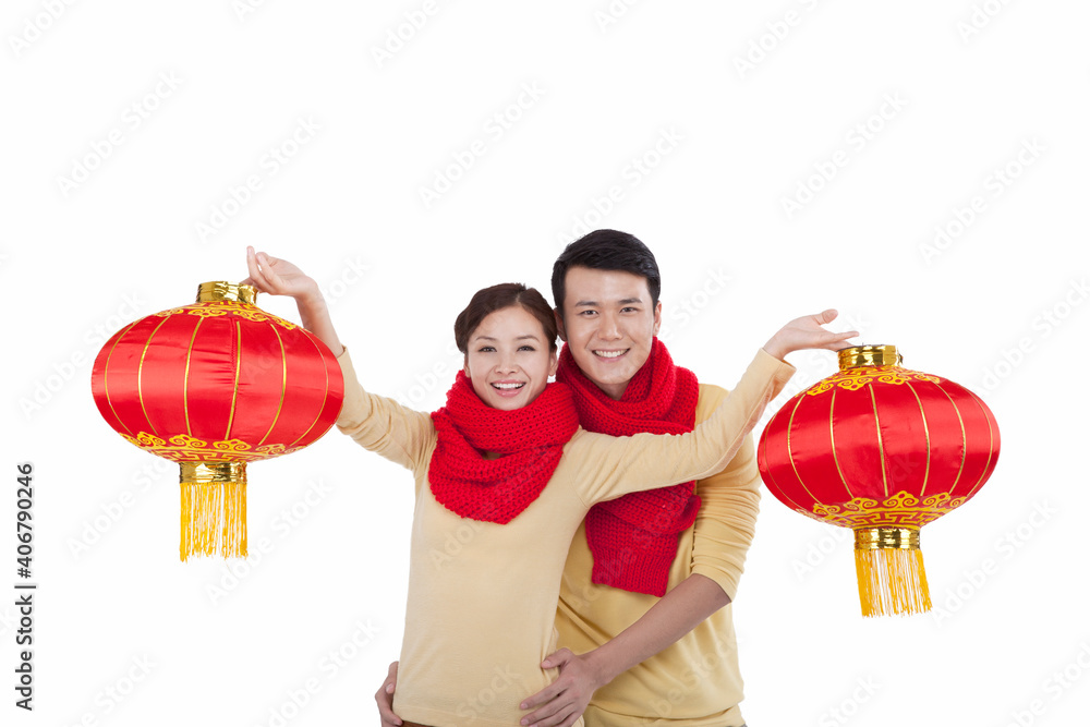 Portrait of young couple holding red lanterns,paying New Year call 