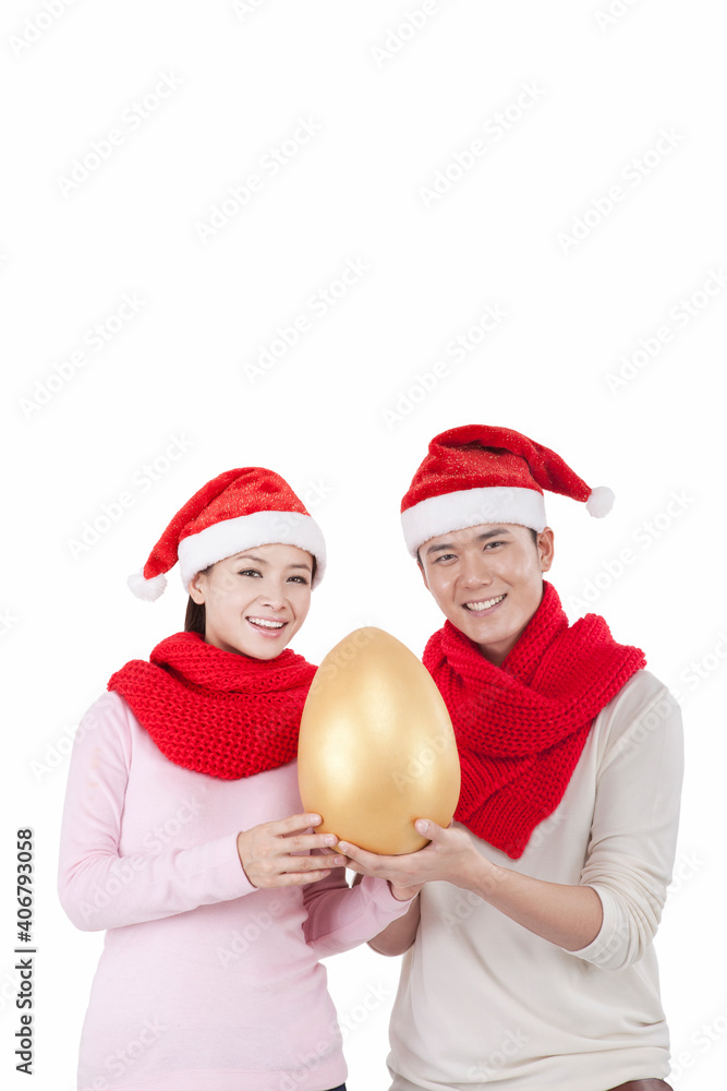 Portrait of young couple wearing Santa hats,holding Jin Dan