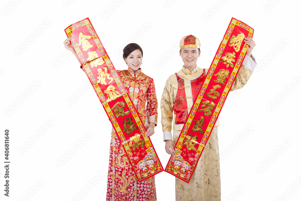 Portrait of young couple in Tang suits holding couplets