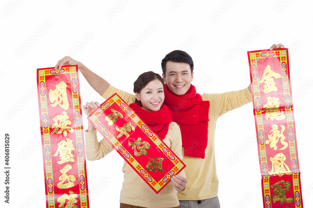 Portrait of young couple holding couplets,paying New Year call 