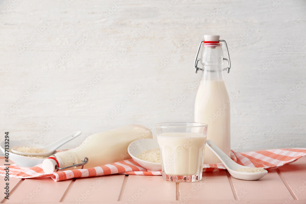 Bottles and glass of rice milk on table