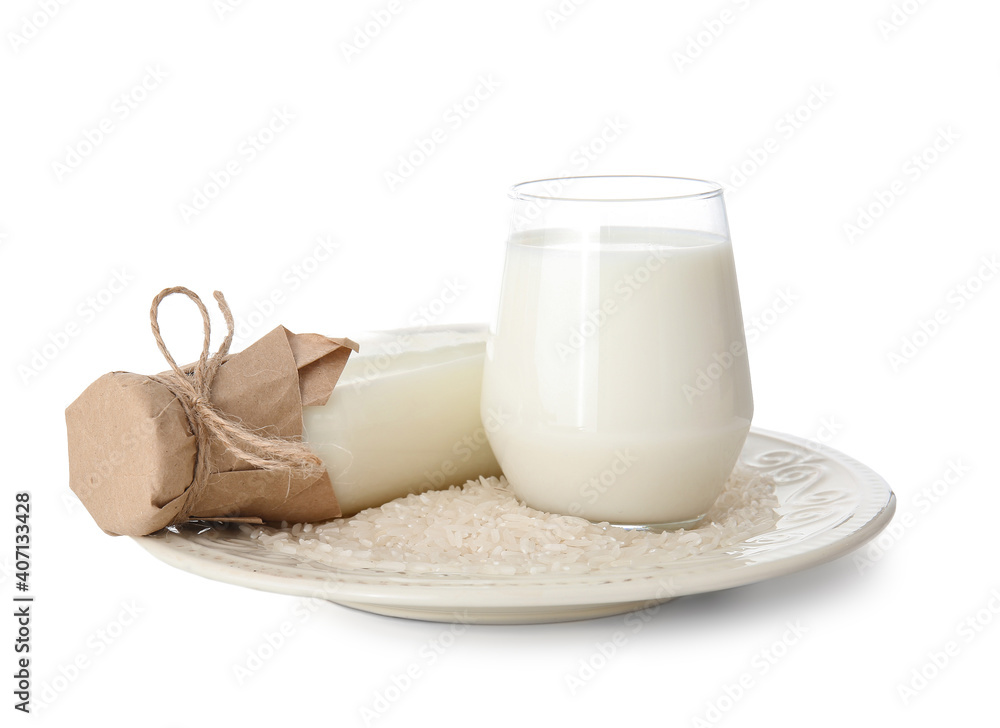 Bottle and glass of rice milk on white background