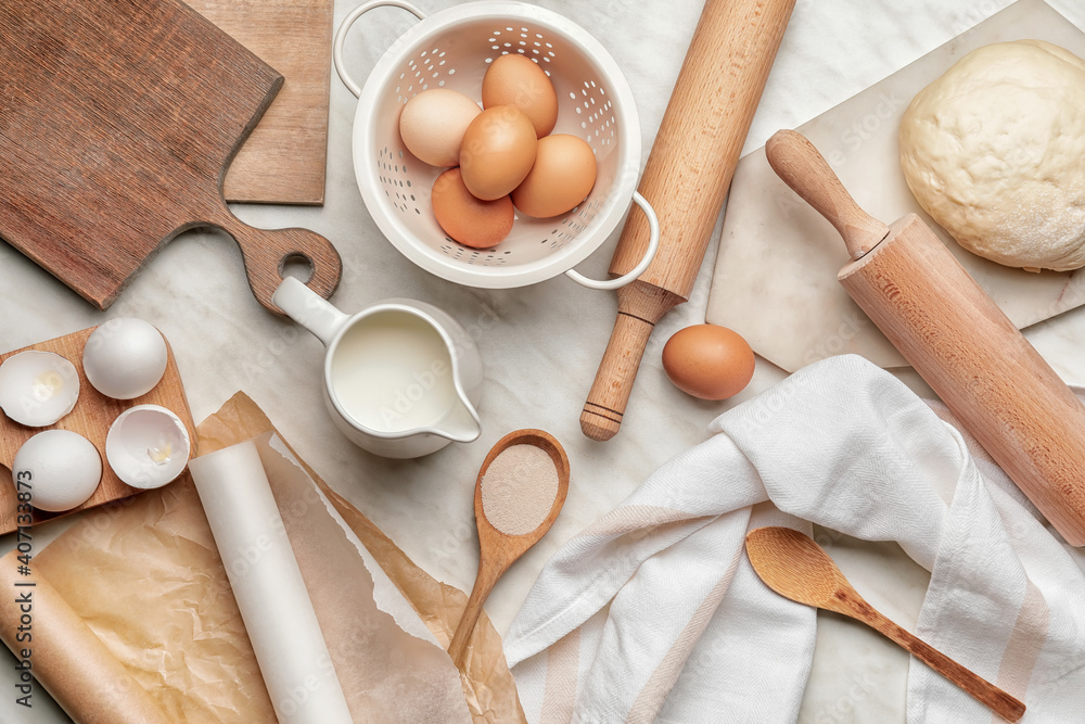 Dough, ingredients and rolling pin on light background