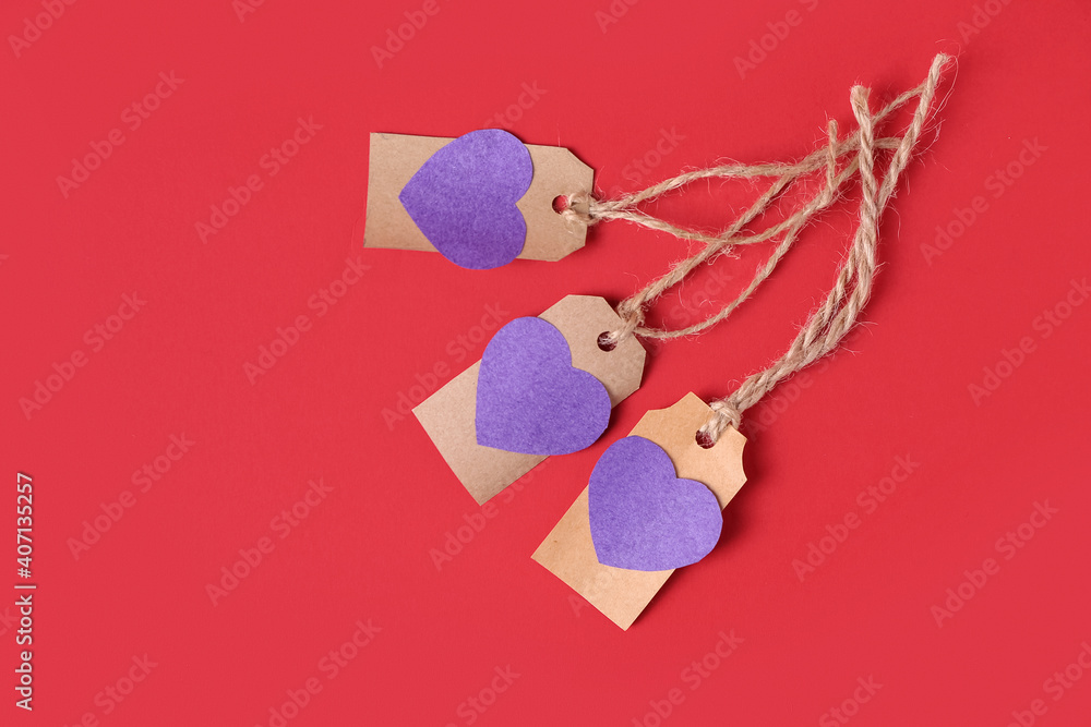 Shopping tags with paper hearts on color background