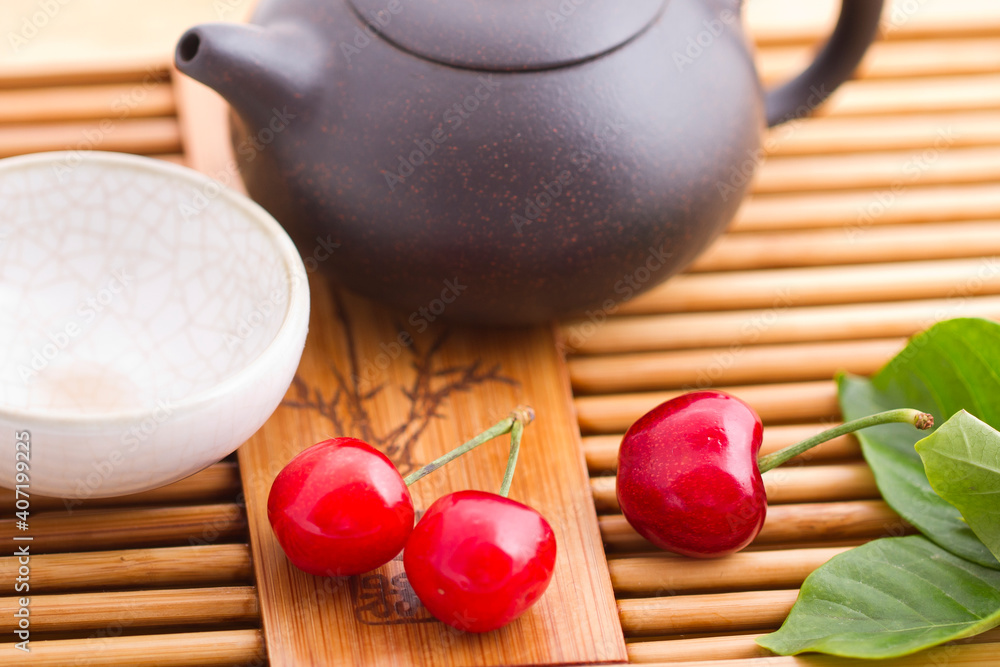 Cherry,teapot,teacup and leaves on tray