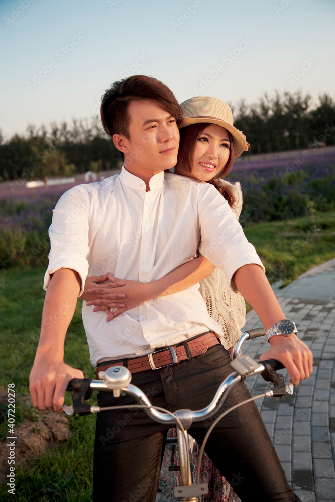 The young couple riding a bicycle