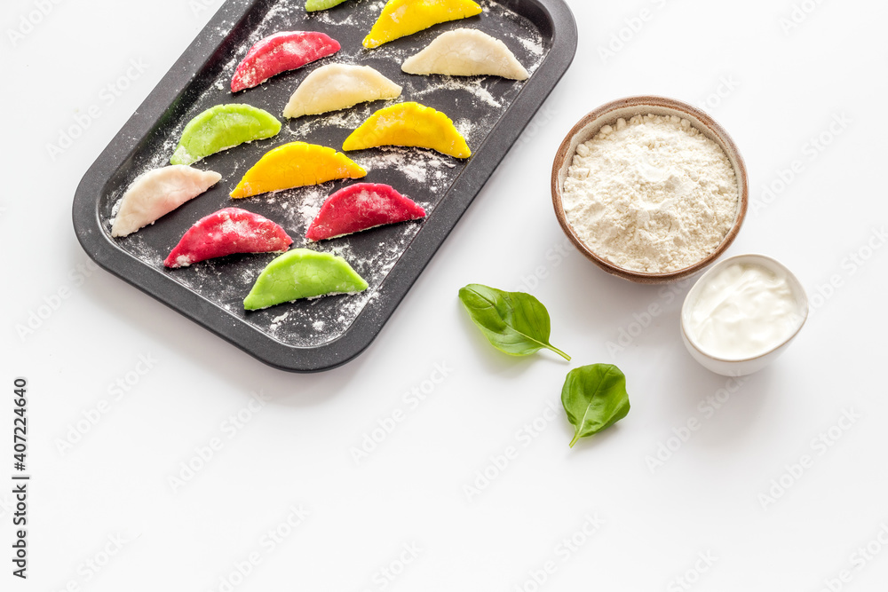 Chinese colorful raw dumplings on baking sheet, top view