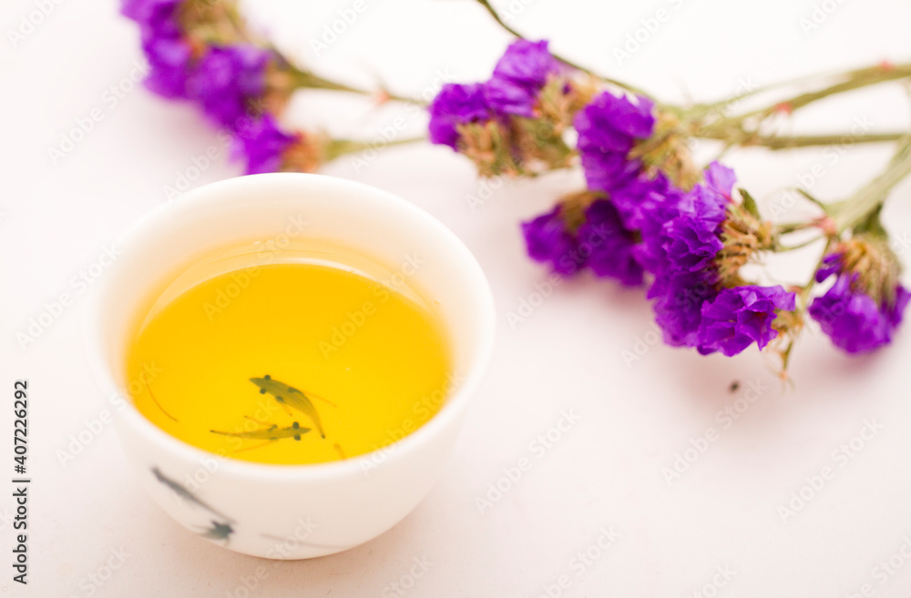 A cup of chinese tea with a bunch of purple flower