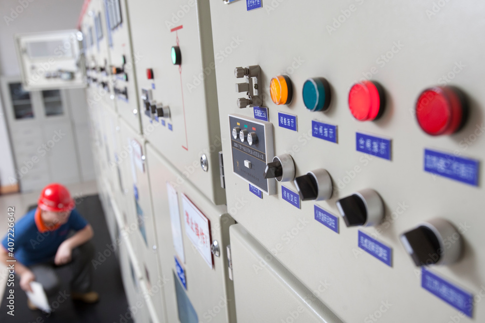 Electrical worker checking the monitoring equipment in the control room